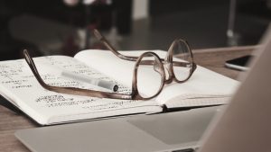 a pair of glasses rest on a notebook